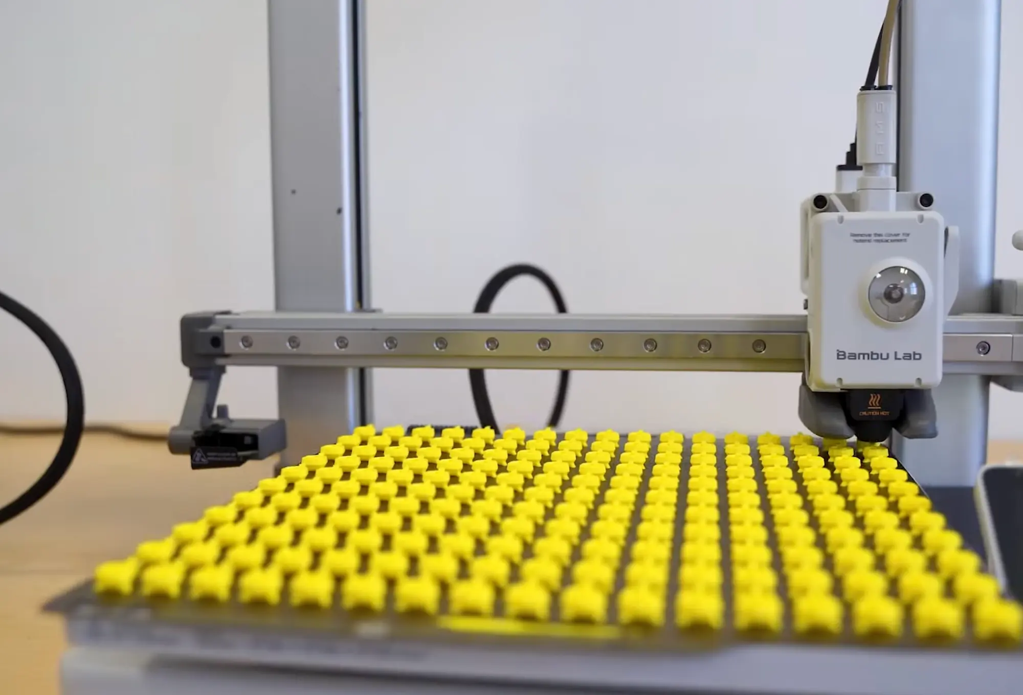 Drukarka 3D z żółtymi wydrukami na płycie roboczej
