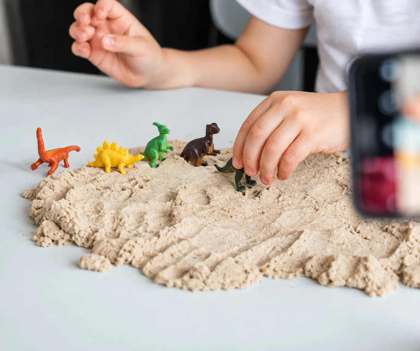 Figurki dinozaurów na piasku kinetycznym