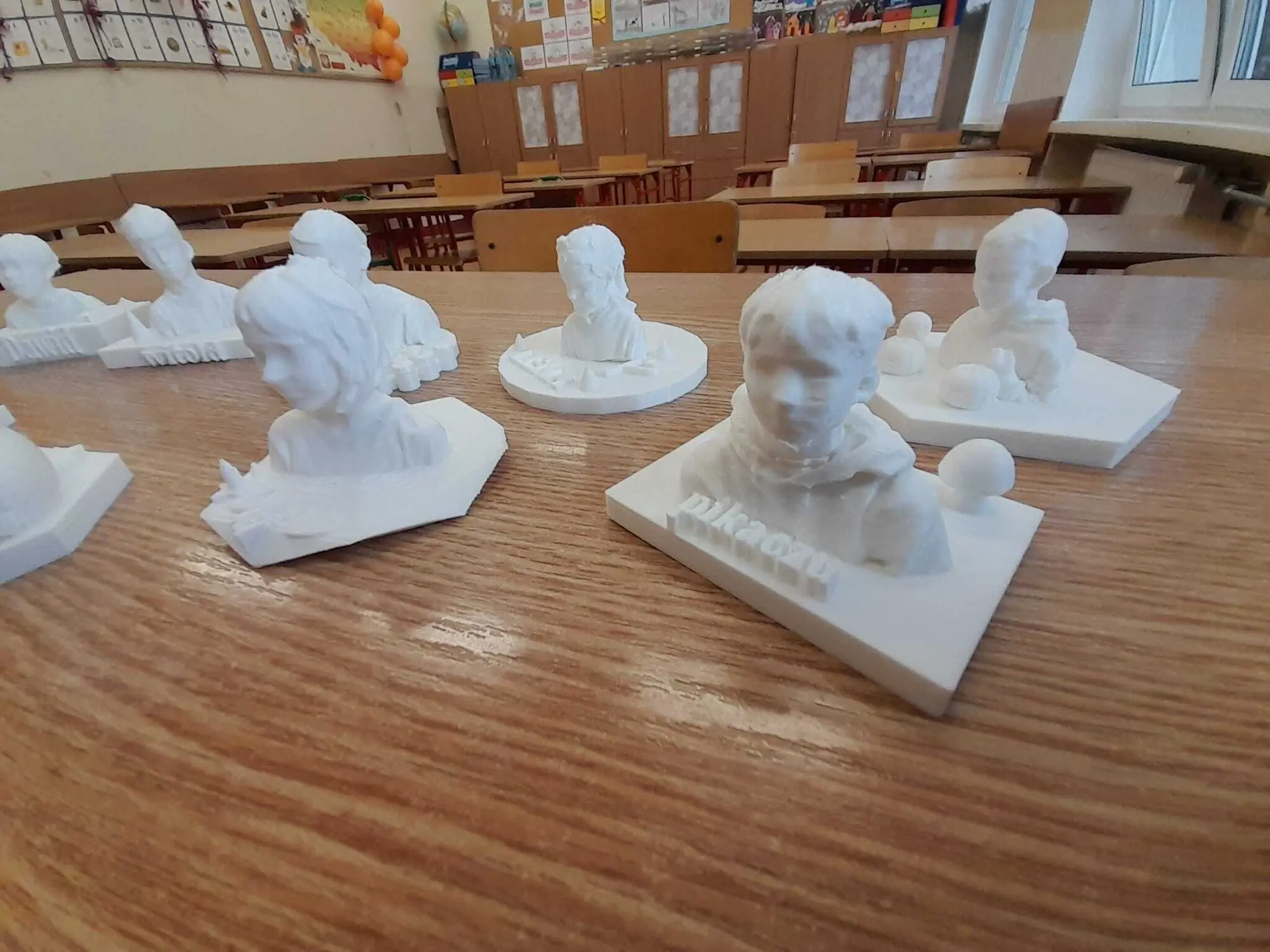 Białe wydrukowane popiersia 3D na drewnianym blacie